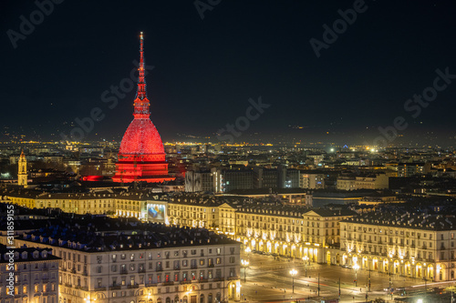 Scenic night cityscape of Turin with the Mole Antonelliana and Vittiorio square lighted in red in Christmas time, Italy