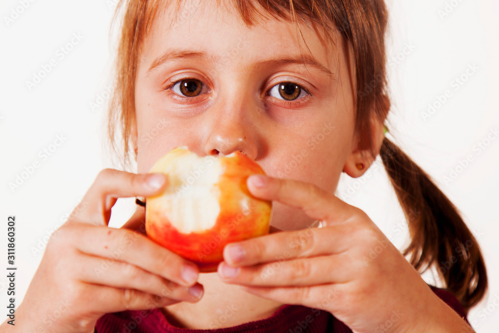 Close up cute child girl bites apple as symbol of diet and healthy food. Close up cute child girl bites apple as symbol of diet and healthy food.