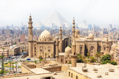 Mosque-Madrassa of Sultan Hassan and the Pyramids in the mist, Cairo, Egypt