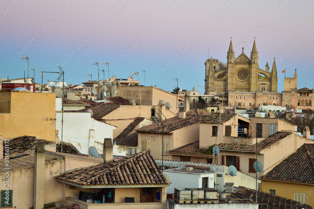 Palma de Mallorca rooftops and architecture with cathedral in the back during sunset, Spain