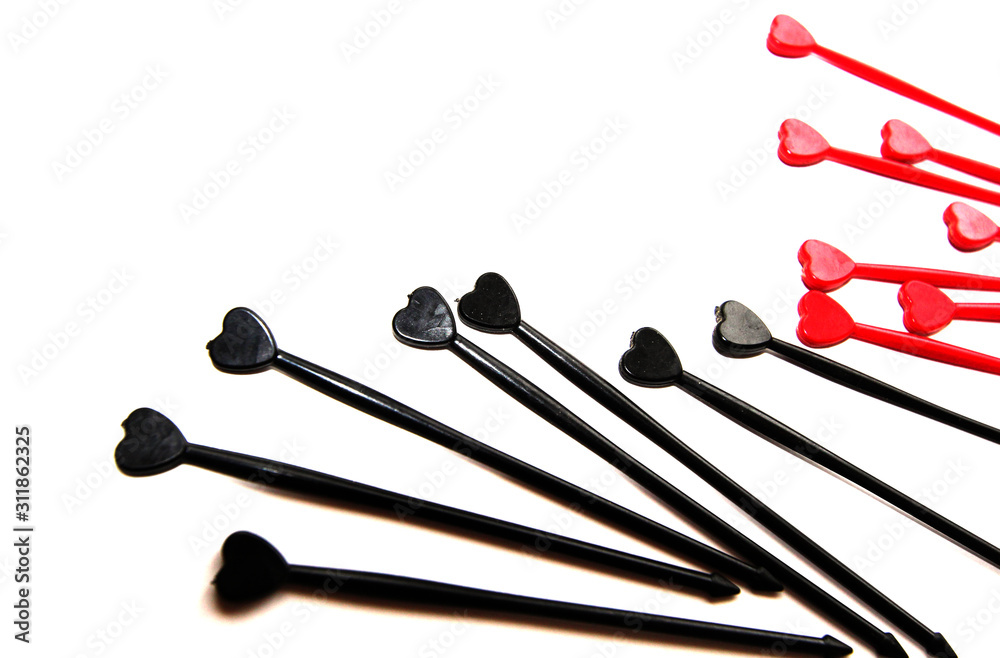 Black and red sticks for canapes whith heart on a white isolated background. Place for text. Black and red sticks for canapes whith heart on a white isolated background. Place for text.