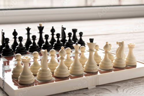 Chessboard with figures on a wooden table. Selective focus.