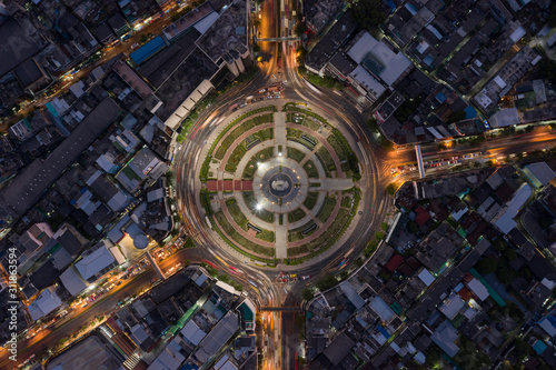 Road roundabout with car lots Wongwian Yai in Bangkok,Thailand. street large beautiful downtown at night light. Aerial view , Top view ,cityscape ,Rush hour traffic jam