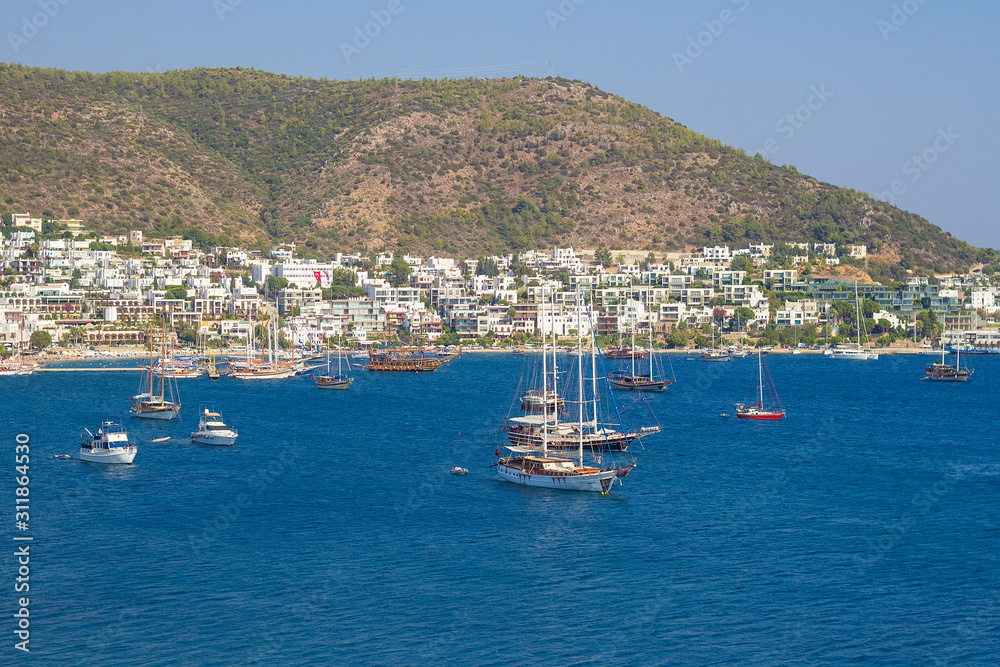 Panoramic view from the walls of famous St Peter Castle  in Bodrum, luxury white yachts, ships and sailing boats near the shores of blue Aegean sea, Mugla, Turkey. Travel concept. Turkish resort