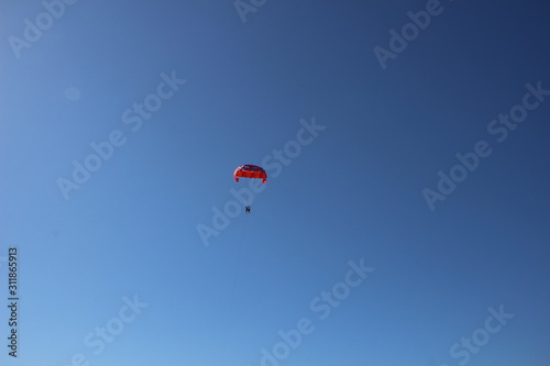 paragliding in the blue sky with colorful parachute