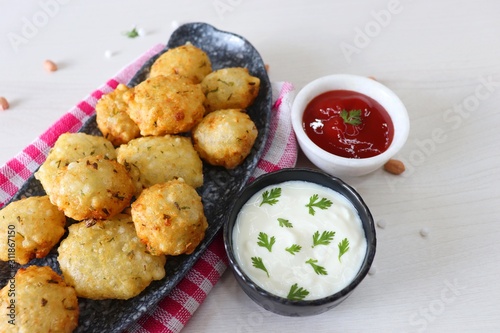 Sabudana vada or Sago fried fitters served with Curd or yogurt and ketchup over white wooden background, popular fasting recipe from India or mostly eaten during Fasting