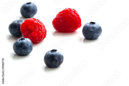 blueberries and raspberries isolated on white