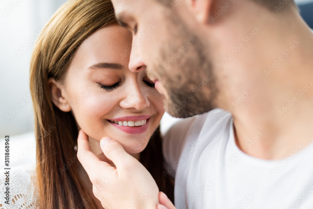 selective focus of man hugging attractive and smiling woman selective focus of man hugging attractive and smiling woman