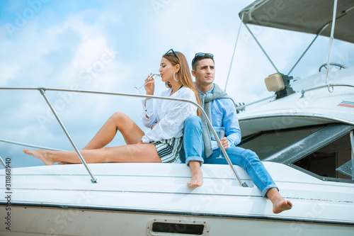 Romantic couple in love on sail boat at under sunlight on yacht. Happy exclusive alternative lifestyle concept. Love story of two lovers. Two young tourists having fun on boat tour in the summertime © Air_Lady