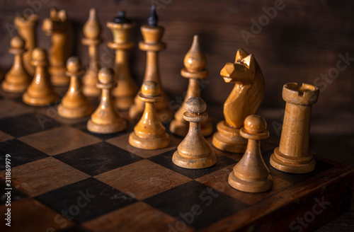 Old vintage wooden chess and a shabby chessboard