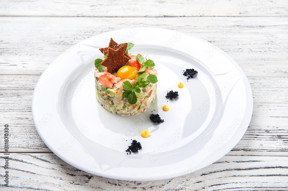 Meat salad in a restaurant close-up. Olivier salad with bread and egg on a white plate and copy space. Meat salad in a restaurant close-up. Olivier salad with bread and egg on a white plate and copy space.