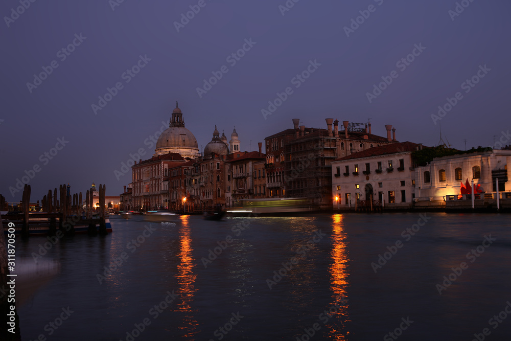 Italy, Venice by night with boats passing by