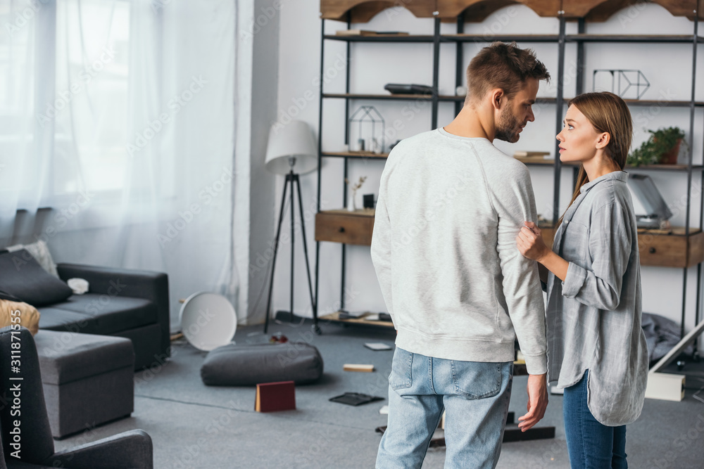 attractive woman talking with handsome man in robbed apartment attractive woman talking with handsome man in robbed apartment