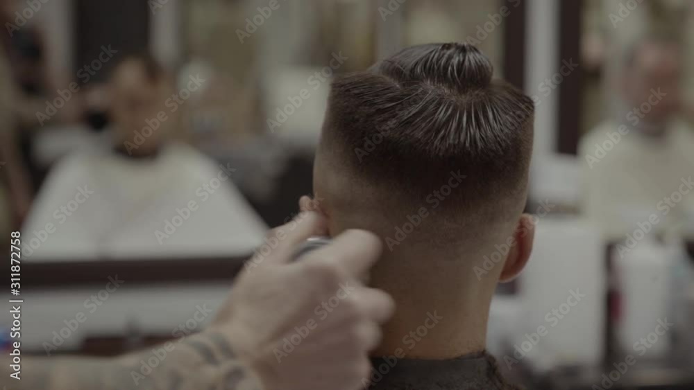 The client receives a haircut in a barbershop. Men's Hair Care. The client receives a haircut in a barbershop. Men's Hair Care.