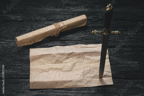 Pirate treasure map template and dagger in wooden table.