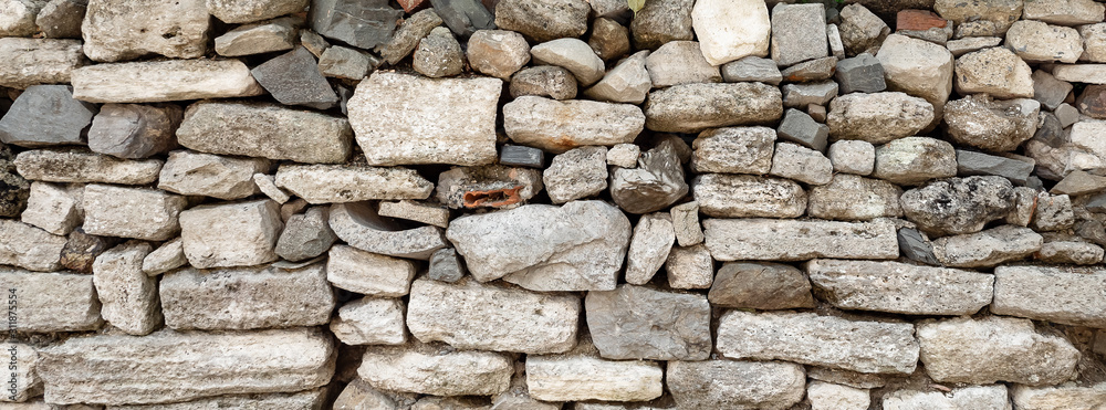 wall made of different stones, not bonded to each other. Texture.