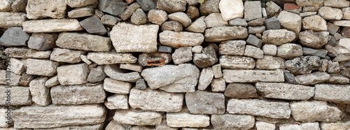 wall made of different stones, not bonded to each other. Texture.