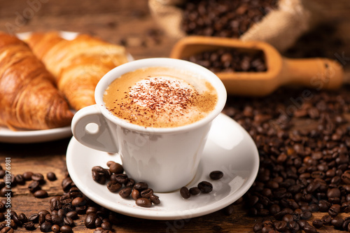 A cup of cappuccino with coffee bean as background. Fototapet