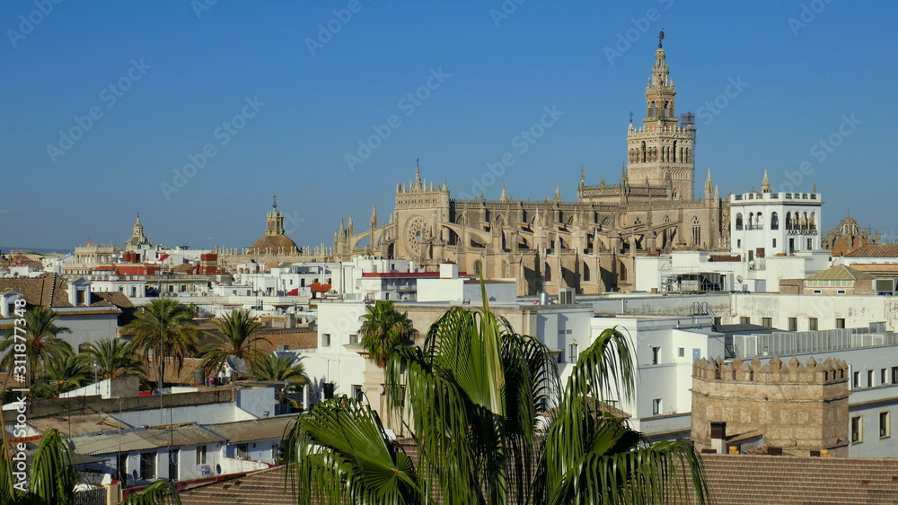 Die Kathedrale Santa Maria erhebt sich über die Stadt Sevilla  in Andalusien vor blauem Himmel