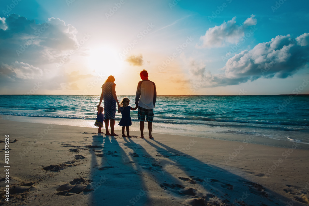 happy family with two kids walk on sunset beach