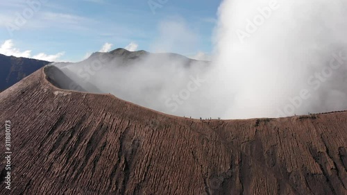 Wallpaper Mural Aerial shot of smoking Mount Bromo, shot of tourists walking on pathway on crater edge, steady shot, horizon view. Java, Indonesia Torontodigital.ca
