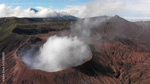 Wallpaper Mural Aerial shot of smoking Mount Bromo, shot of Bromo landscape with Semeru mountain in the background, blue sky, Java, Indonesia Torontodigital.ca