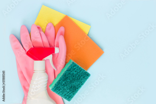 Detergents  cleaning accessories  rubber glove  rags and sponge for dishwashing on a blue background. Cleaning service concept. Top view  flat lay. Copy space.