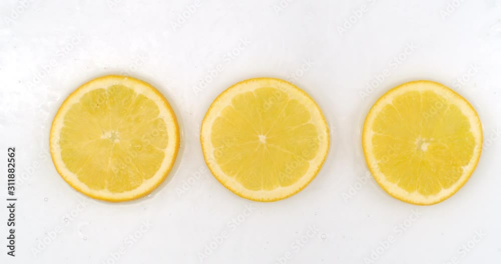 Super Slow Motion Shot of Splashing Water to three orange Slices view from above. Super Slow Motion Shot of Splashing Water to three orange Slices view from above.