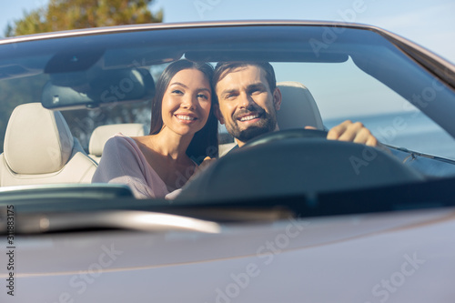 front view of multiethnic couple driving in the auto