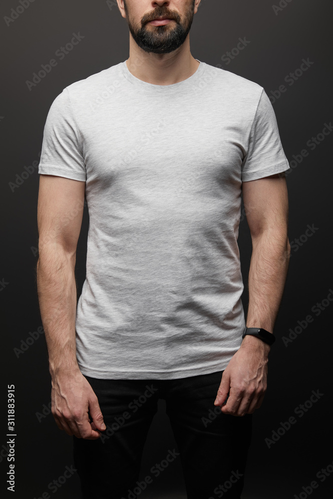 cropped view of bearded man in blank basic grey t-shirt isolated on black cropped view of bearded man in blank basic grey t-shirt isolated on black