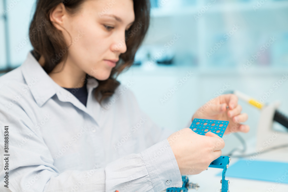 Student woman in robotics laboratory working on project mechatronics Student woman in robotics laboratory working on project mechatronics