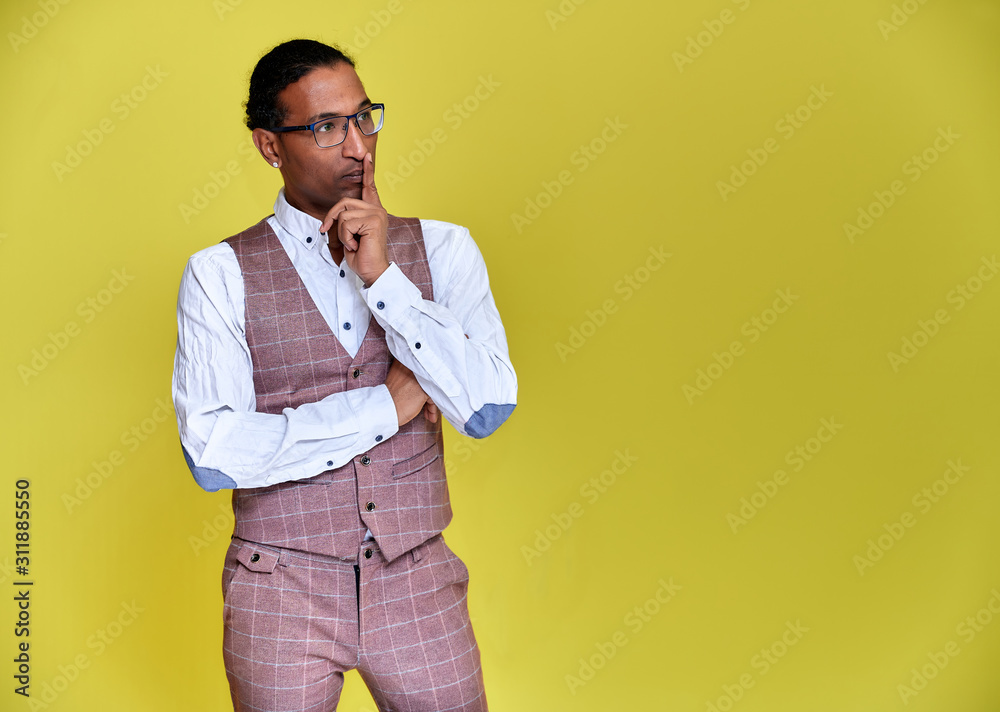 Portrait of a young African American man with short haircuts and a white-toothed smile in a business suit on a yellow background. Standing and talking right in front of the camera. Portrait of a young African American man with short haircuts and a white-toothed smile in a business suit on a yellow background. Standing and talking right in front of the camera.