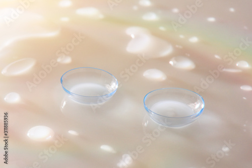 Contact lenses macro on white glass table with color reflections