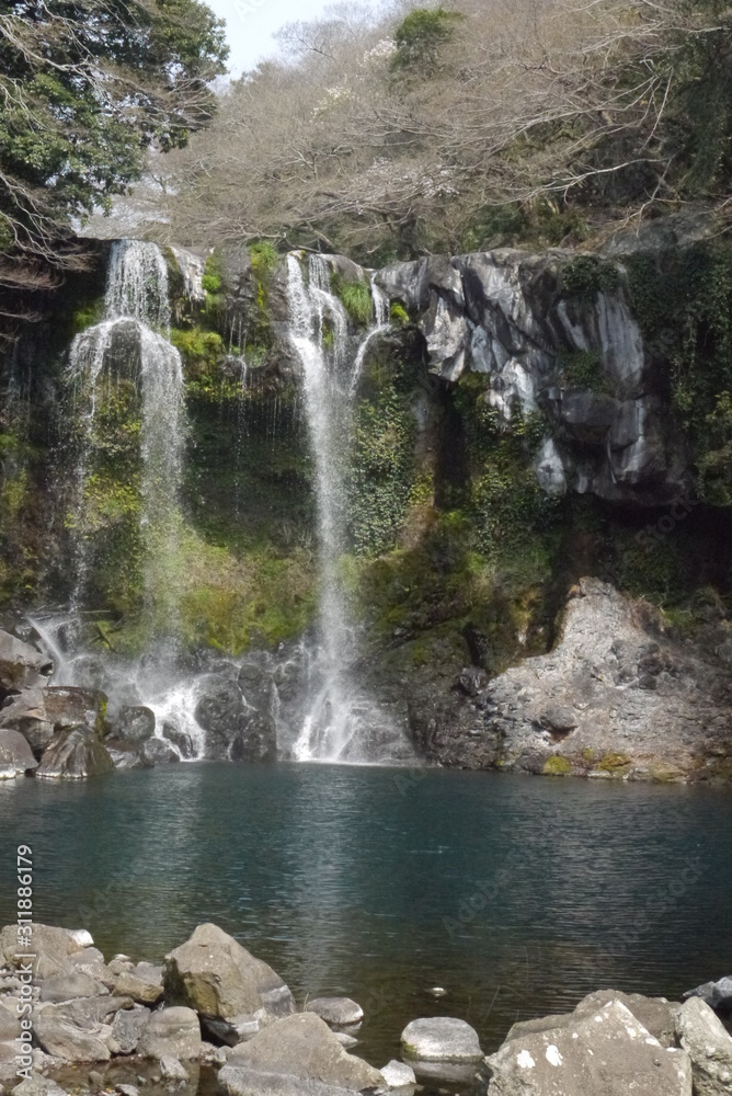 Obraz premium horizontal view on Cheonjiyeon Waterfall in the morning sun, Jeju Island, South Korea, Asia