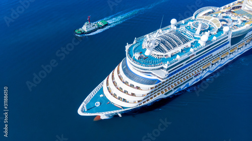 Aerial view of beautiful white cruise ship above luxury cruise running with tug boat in the ocean sea concept tourism travel on holiday take a vacation time on summer. forwarder mast