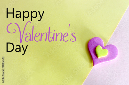 A plump pink and yellow heart shape on a matching background. Harsh lihgting and hard shadows enhance the pop art styling. Valentine's Day message photo