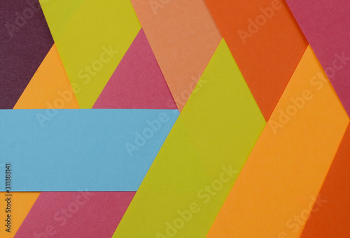 Layers of colored, rough textured construction paper creating a graphic template. Abstract design geometric style color blocks. Copyspace.