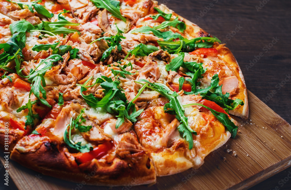 Pizza with Mozzarella cheese, salmon fish, tomato sauce, pepper. Italian pizza on wooden table background Pizza with Mozzarella cheese, salmon fish, tomato sauce, pepper. Italian pizza on wooden table background