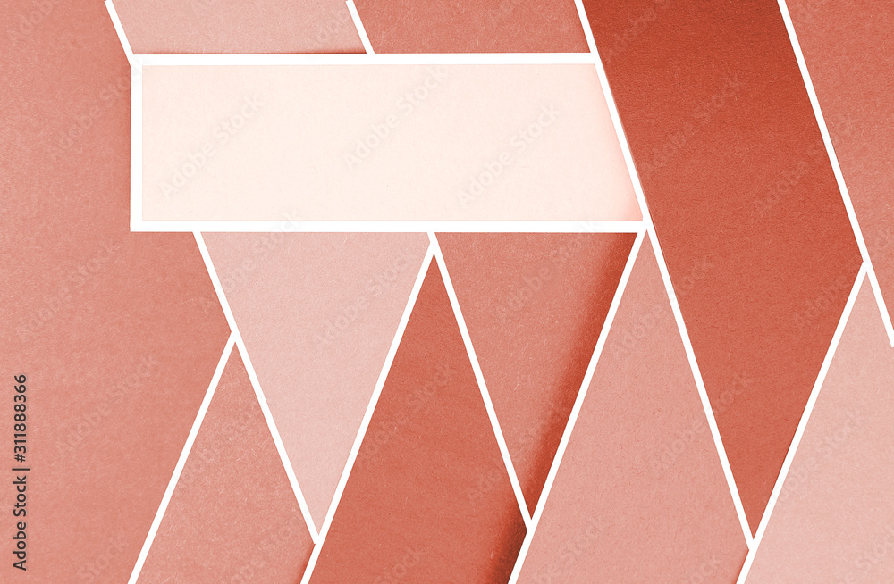 Layers of colored, rough textured construction paper creating a graphic template. Abstract design geometric style color blocks. Copyspace. Shades of coral and blush