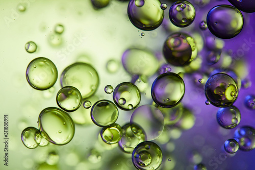 creative purple and green color abstract background from mixed water and oil bubbles