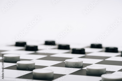 Selective focus of checkers on chessboard isolated on white