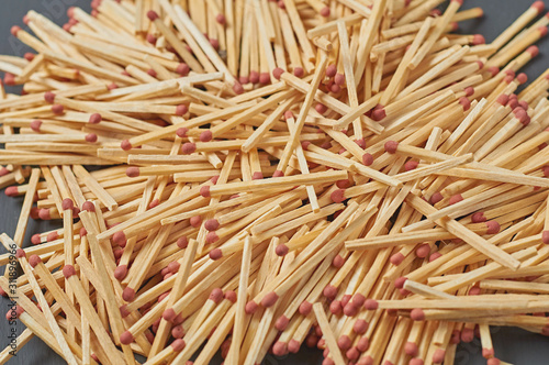 Heap of many matches with red sulfur on dark concrete desk on kitchen. Close-up