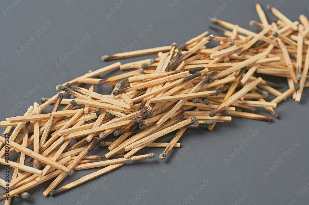 Row of many used matchsticks with burnt sulfur on dark concrete table on kitchen. Close-up Row of many used matchsticks with burnt sulfur on dark concrete table on kitchen. Close-up