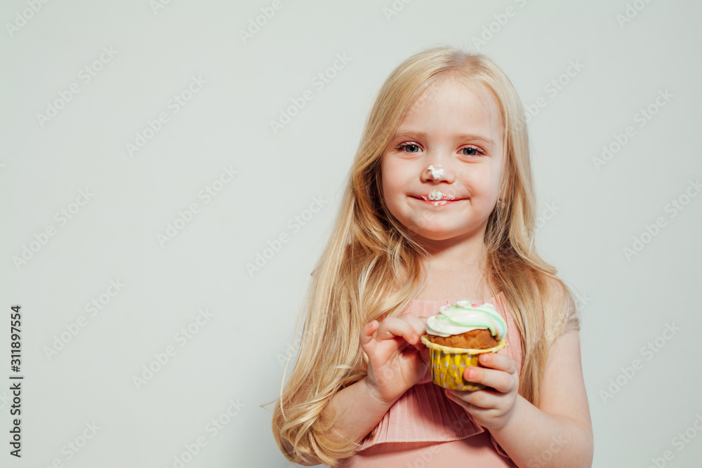 beautiful little girl blonde with cake and candy portrait of food