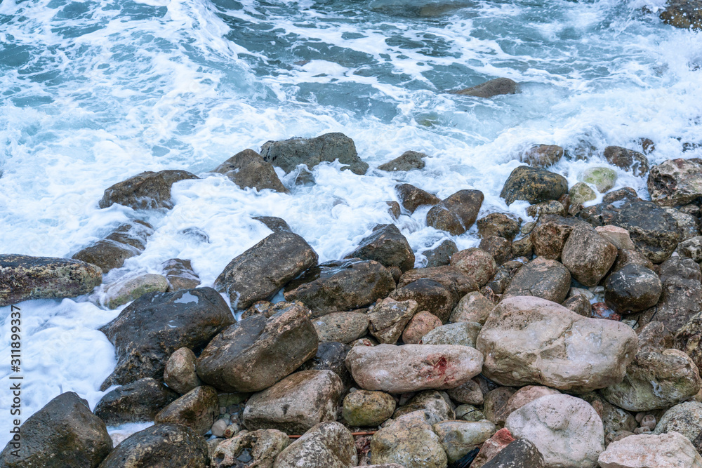 Aerial view of a coast in a cove, waves crashing against the rocks in a stormy day, fury of the sea in Majorca, Balearic Islands, Spain. Aerial view of a coast in a cove, waves crashing against the rocks in a stormy day, fury of the sea in Majorca, Balearic Islands, Spain.