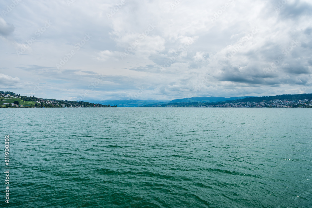 Beautiful lake Zurich landscape. Cloudy skyscape with background of Alps mountains peaks. Beautiful lake Zurich landscape. Cloudy skyscape with background of Alps mountains peaks.