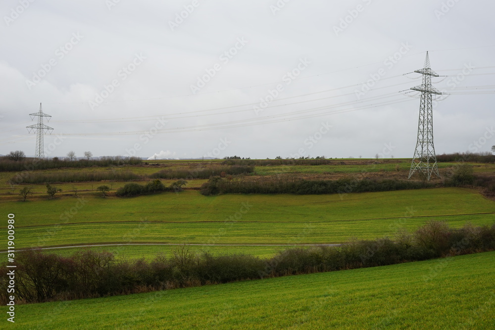 Bäuerliche Landschaft mit Feldern und Strommasten