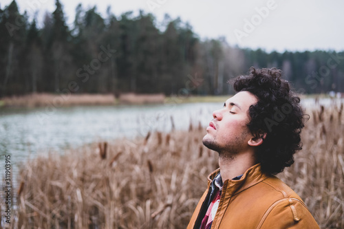 Latin American man looking relaxed at a lake 