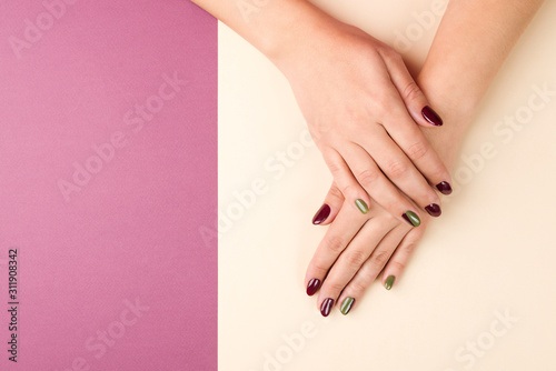 Woman hands with creative manicure. Beautiful woman hands on beige background, top view, copy space