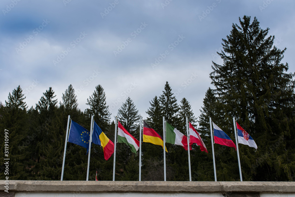 Waving european flags in local international World War 1 and 2 memorial park in Transylvania, Romania.